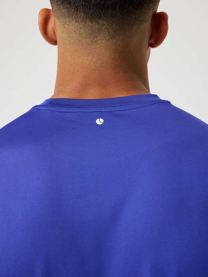 Borg T-Shirt i Clematis Blue (Blå) set bagfra i nærbillede med hvidt tennisbold-logo til træning og tennis.
