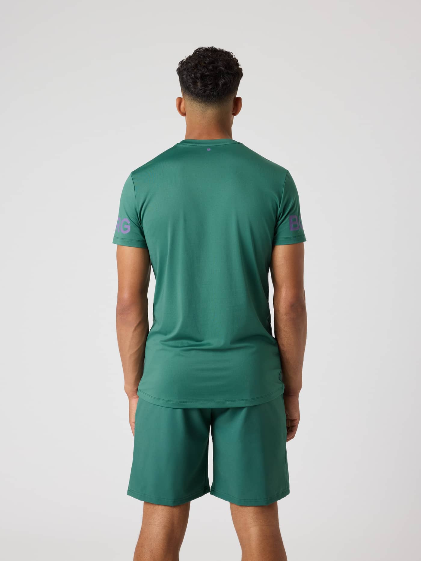 Borg T-Shirt i Mallard Green (Grøn) set bagfra med lilla logoer og en længere ryg til træning. - Image 2