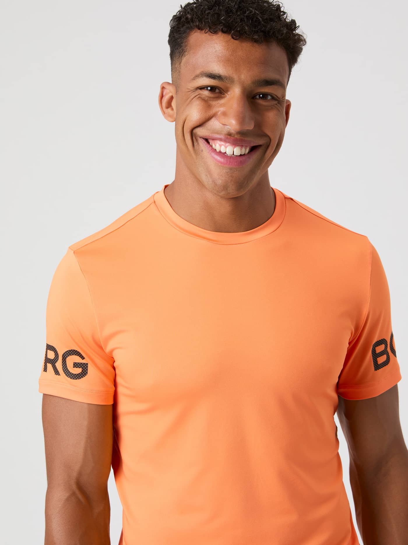 Close-up of a model wearing the Björn Borg T-shirt in Papaya orange. - Image 1