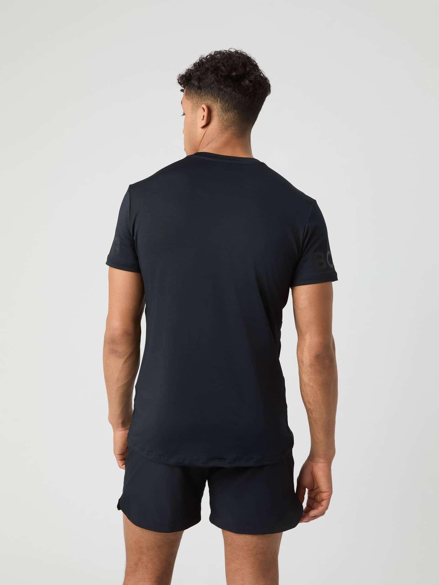Borg T-Shirt i Black Tonal Logo (Sort) set bagfra på en model, med en funktionel pasform til træning og tennis. - Image 2