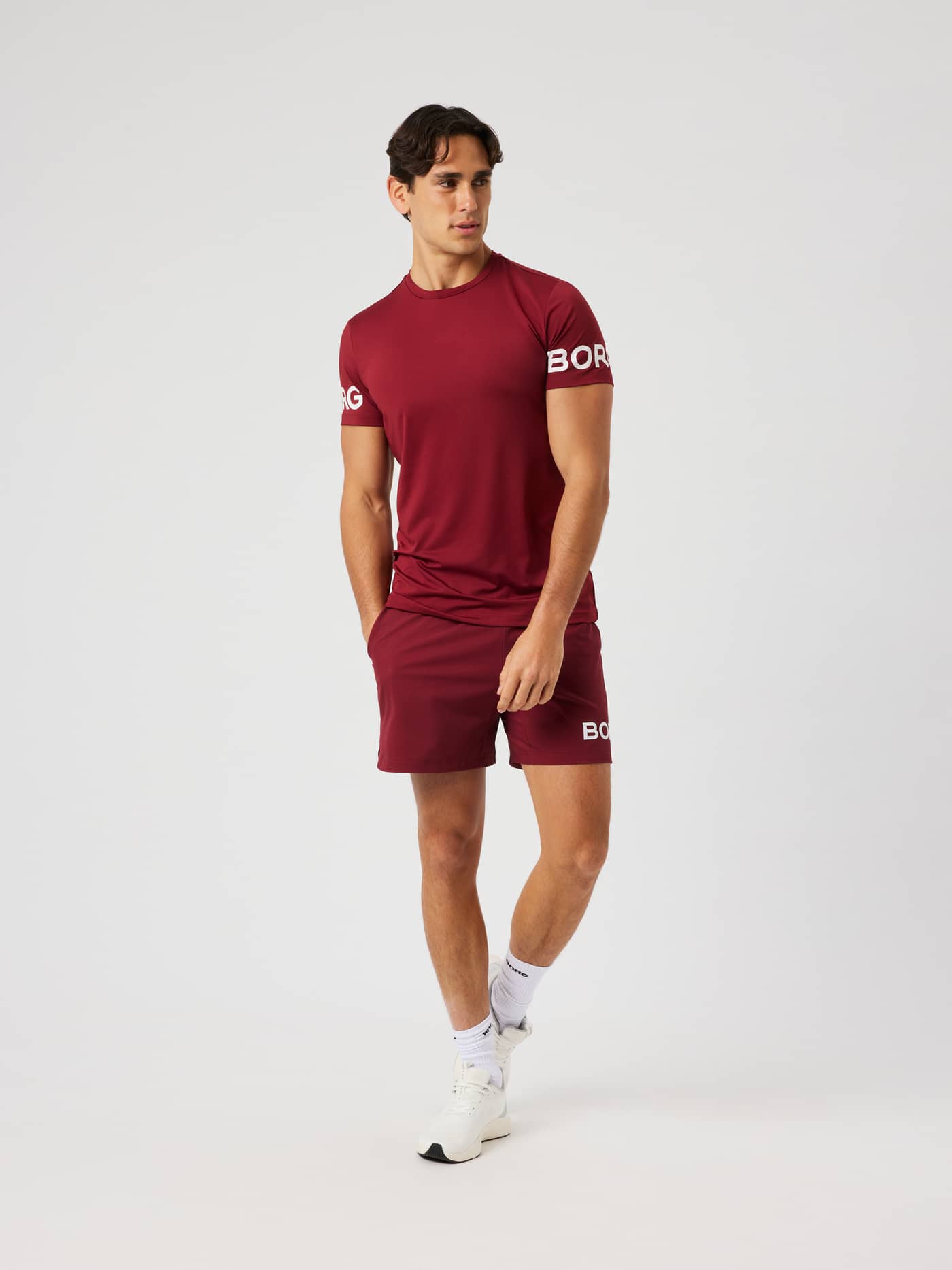 Man wearing the Borg T-Shirt in Cabernet (red) featuring white arm logos for training. - Image 5