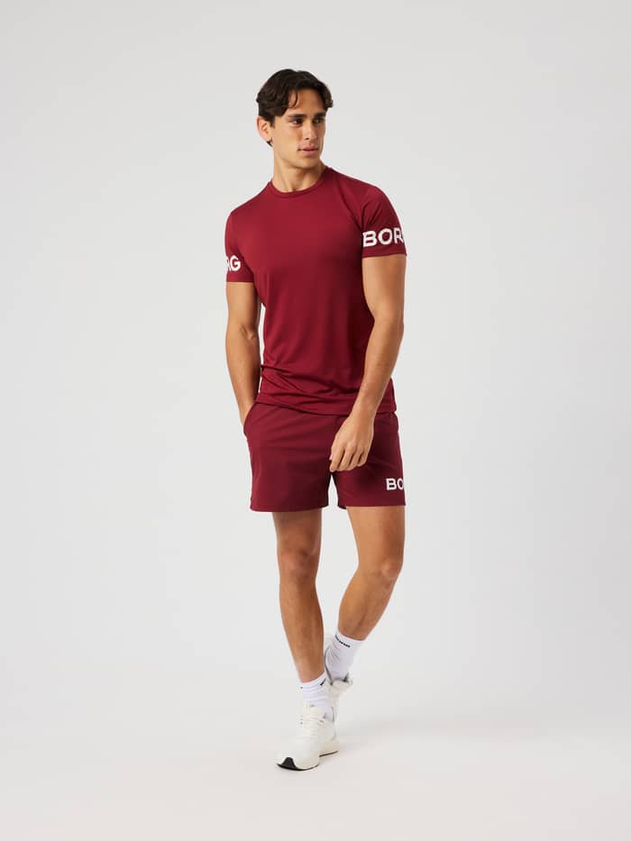Man wearing the Borg T-Shirt in Cabernet (red) featuring white arm logos for training.