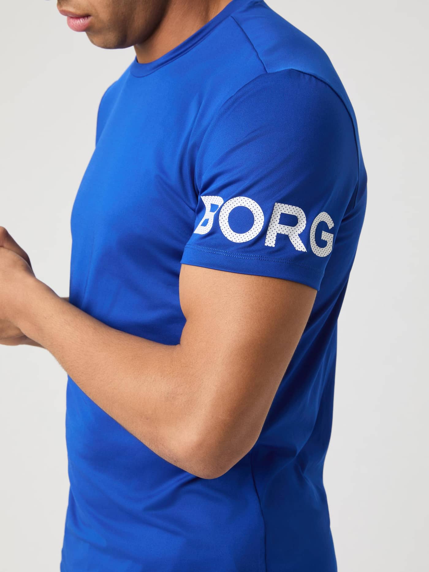 Close-up side view of a man wearing the blue Borg T-shirt, showing the white BORG logo on the sleeve. - Image 4
