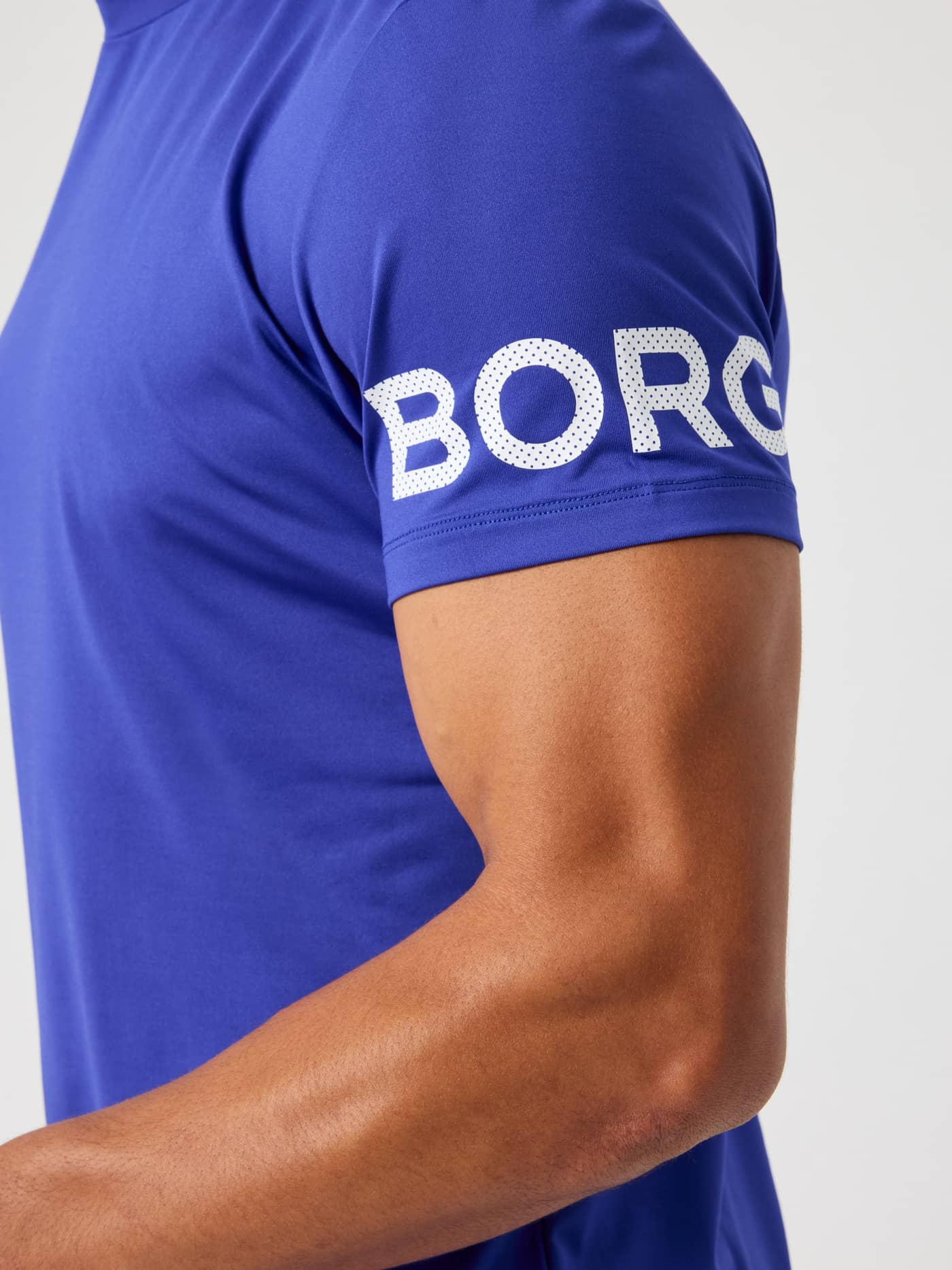 Nærbilde av Borg T-Shirt i Clematis Blue (Blå) til trening, med en hvit perforert logo på ermet. - Image 6