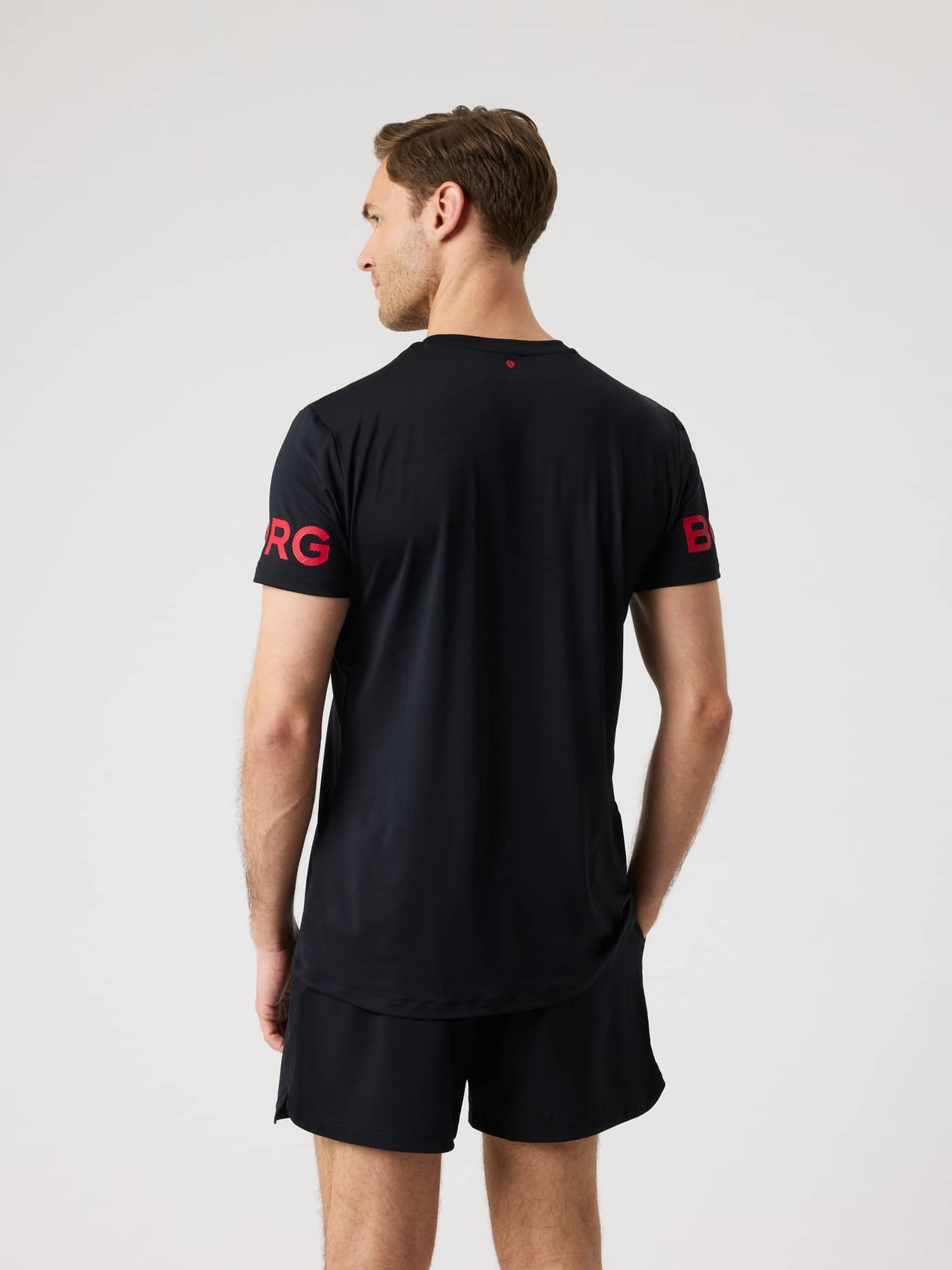 Borg T-Shirt i Black Beauty (Sort) set bagfra med røde logoer til performance på tennisbanen. - Image 2
