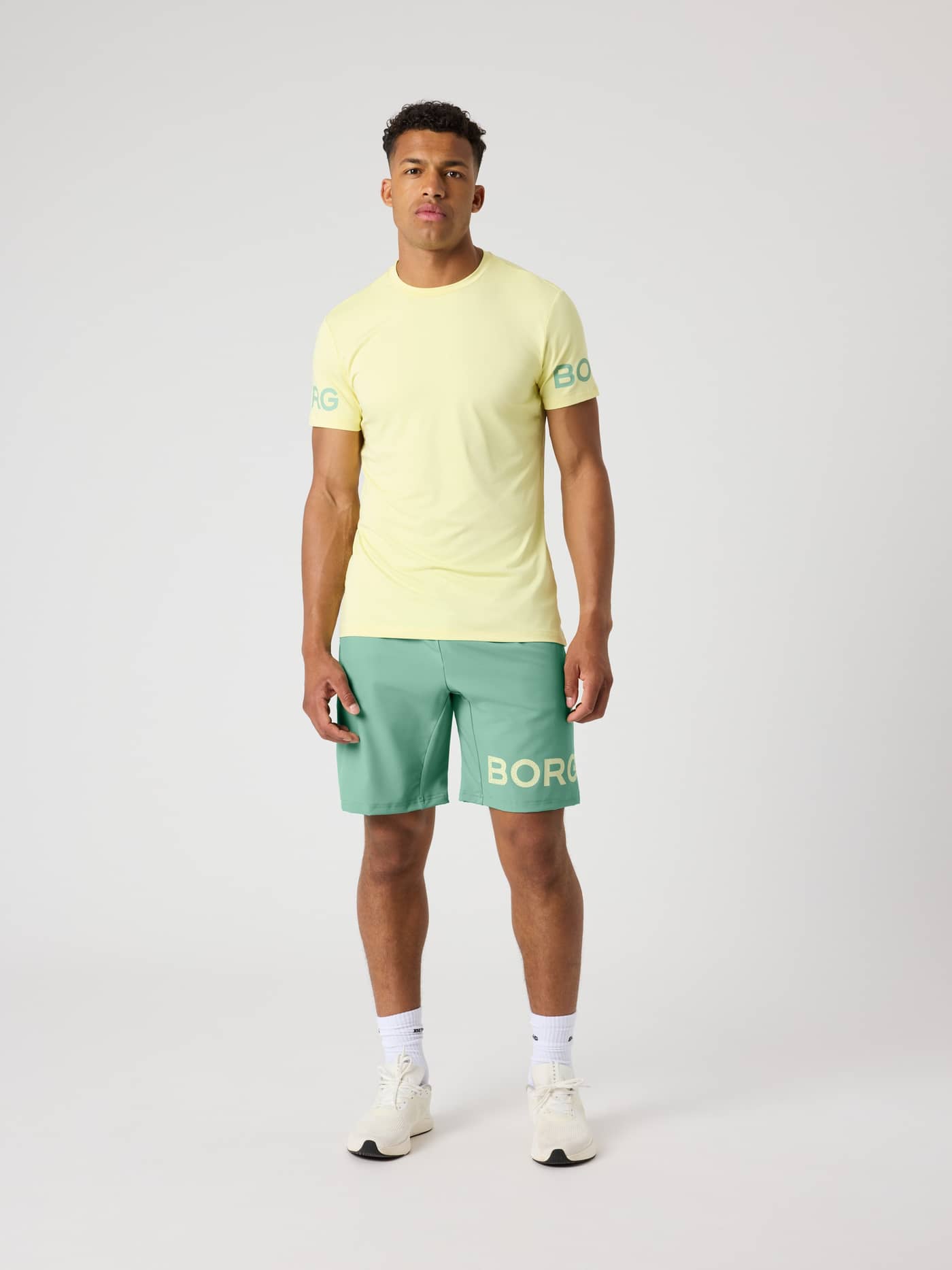 Borg T-Shirt i Lemonade (Gul) set forfra på en mand med grønne logoer på ærmerne til træning. - Image 4