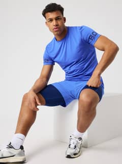 Borg T-Shirt i Amparo Blue (Blå) på en siddende mand med navy ærmelogoer til stilfuld og funktionel træning. - Image 1