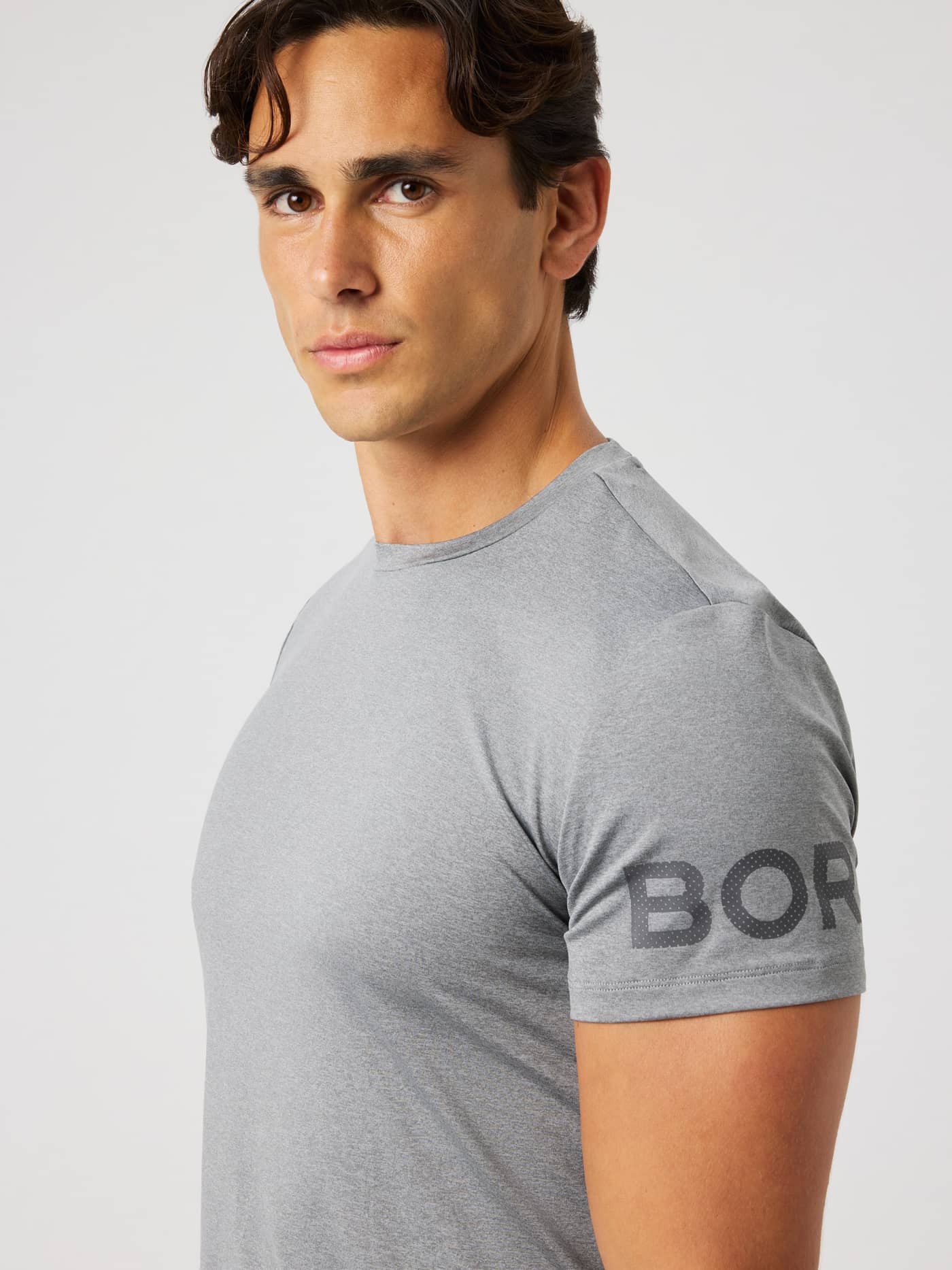 Close-up of the Borg T-Shirt in Grey Melange (grey) highlighting the round neck and sleeve logo for training. - Image 1