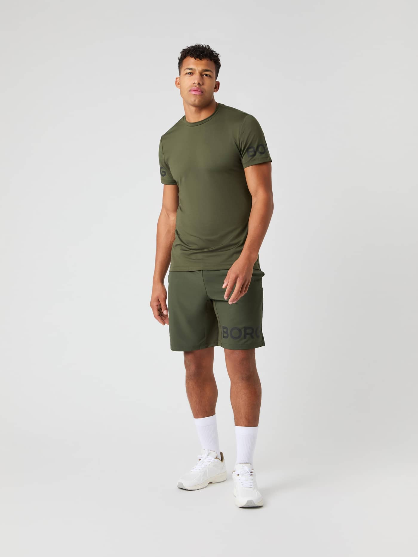 Mandlig model i Borg T-Shirt og matchende shorts i Forest Night (Grøn) set forfra til træning. - Image 4