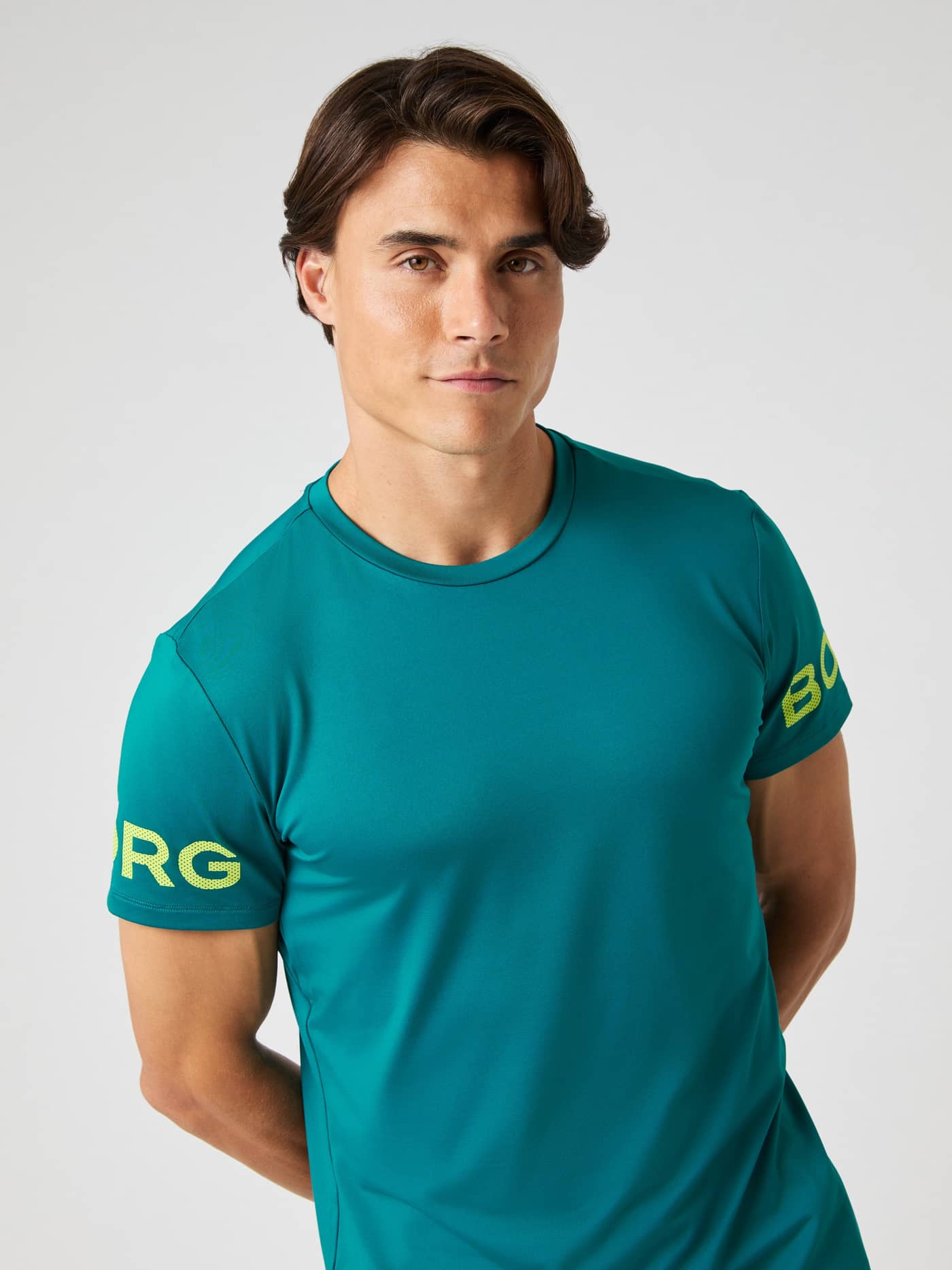 Front view of a model wearing the Borg T-shirt in Shaded Spruce, showing the fit and sleeve logo detail. - Image 2