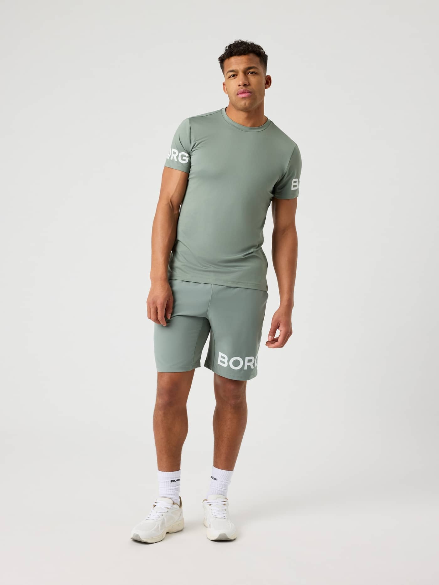Front view of a male model wearing the Agave Green Borg T-shirt and matching shorts. - Image 4