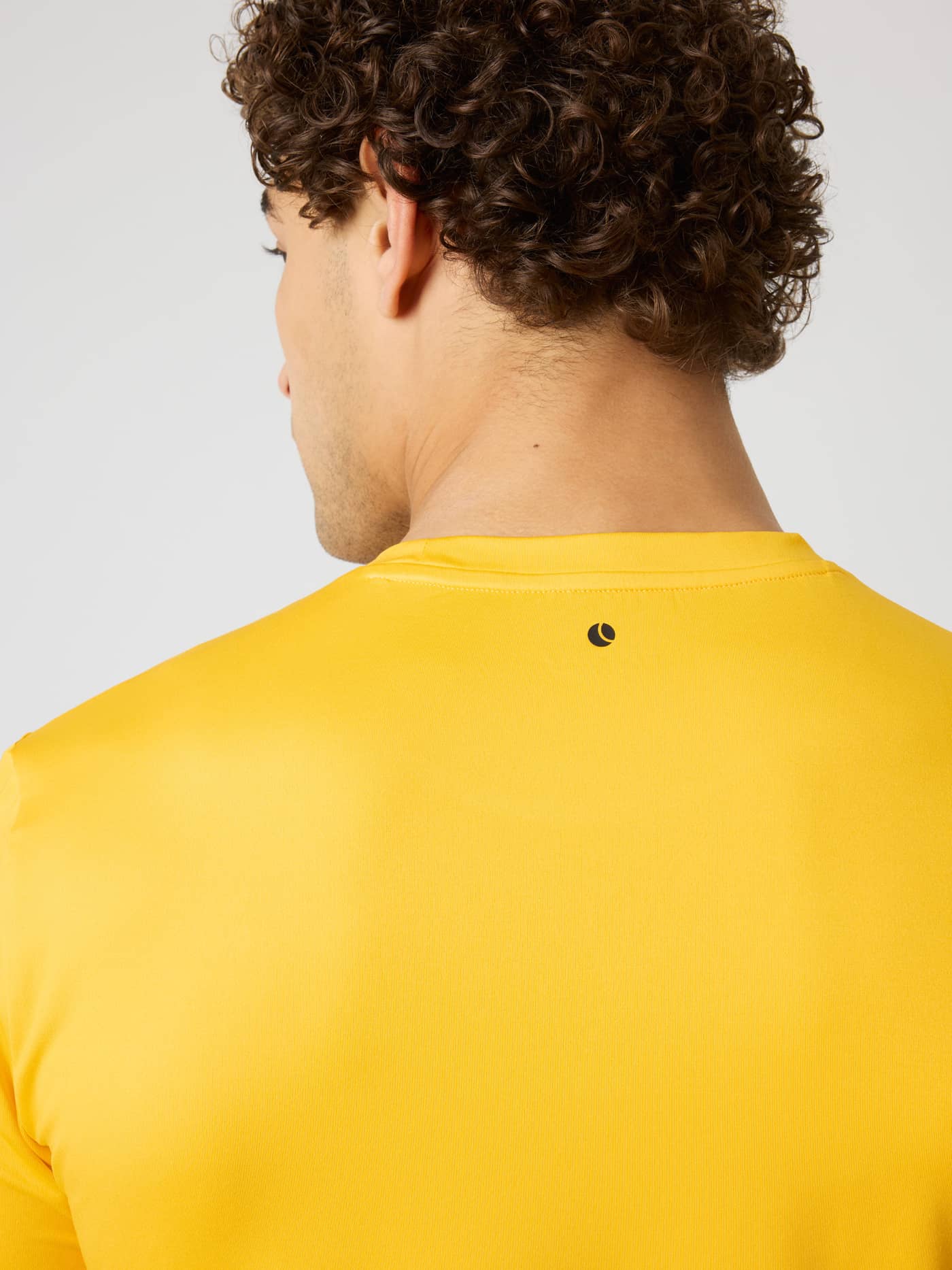 Back view of the Borg T-Shirt in Citrus (Orange) with a black tennis ball print for training and tennis. - Image 5