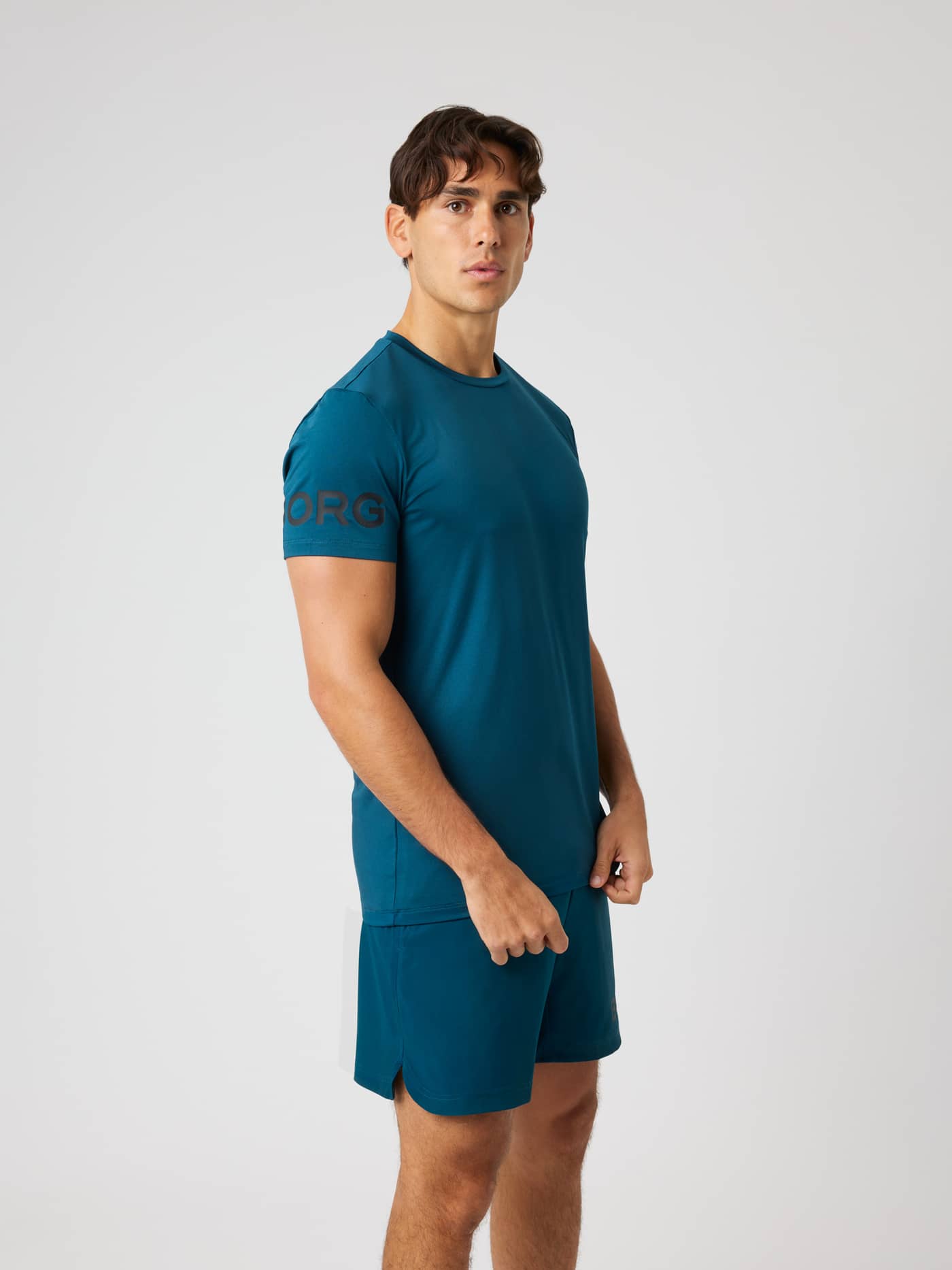 Side view of the Borg T-Shirt in Reflecting Pond (Green) for training and tennis, featuring a perforated logo. - Image 2