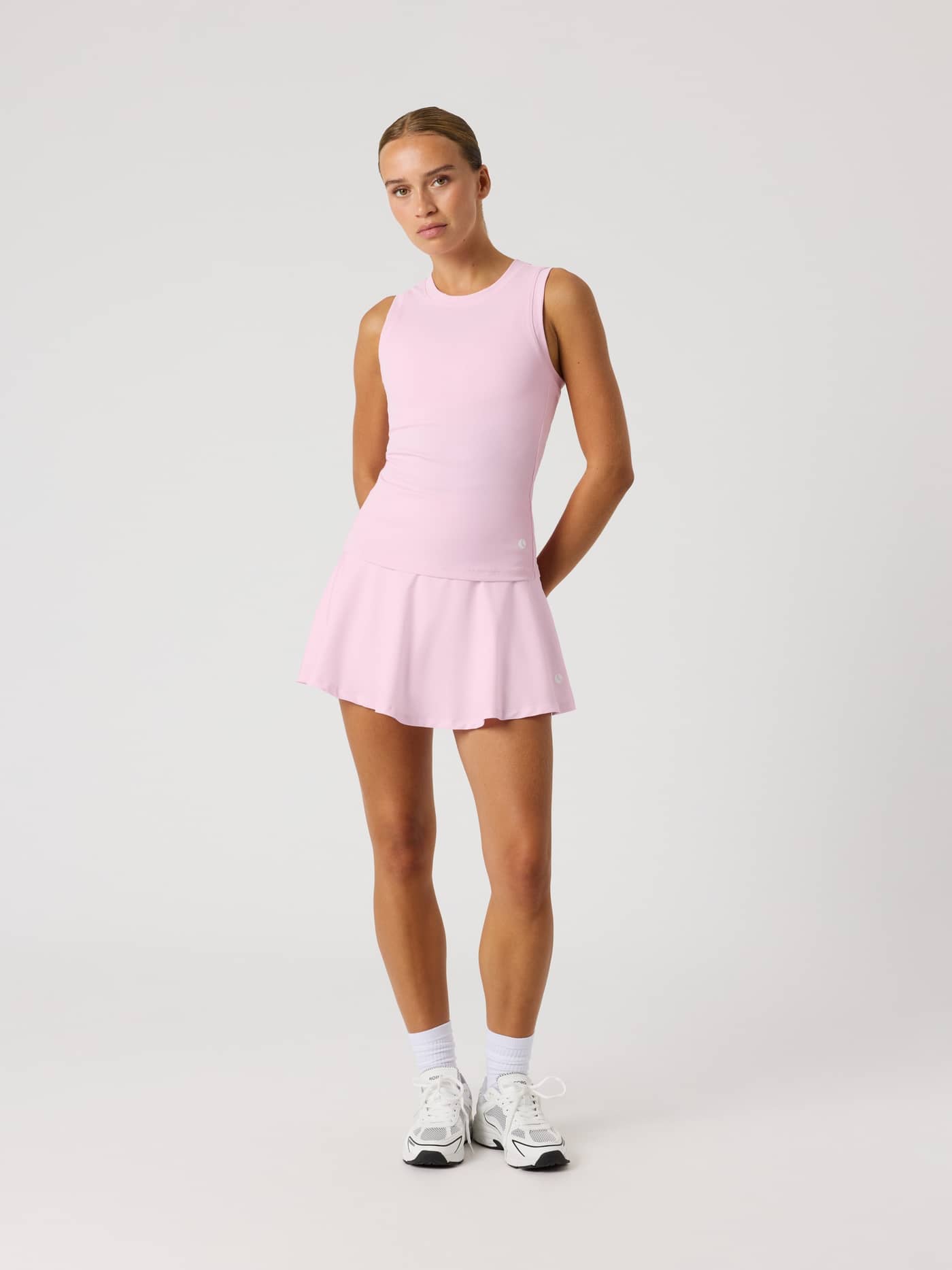 Full-body front view of a model in the pink Björn Borg Ace Pocket Ribbed Tank Top, featuring a slim fit and rib fabric. - Image 3