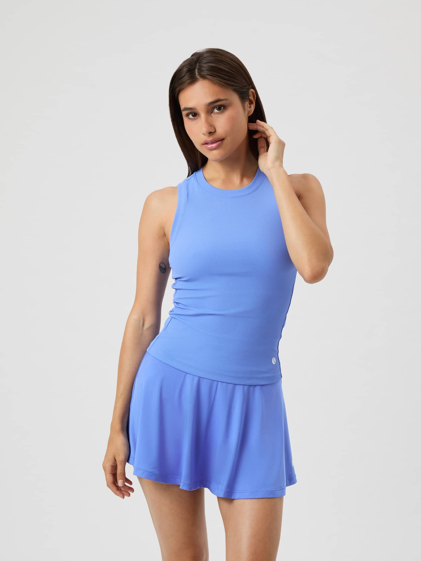 Ace Pocket Ribbed Tank Top i Ultramarine (Blå) för tennis på en modell som bär en matchande kjol. - Image 1