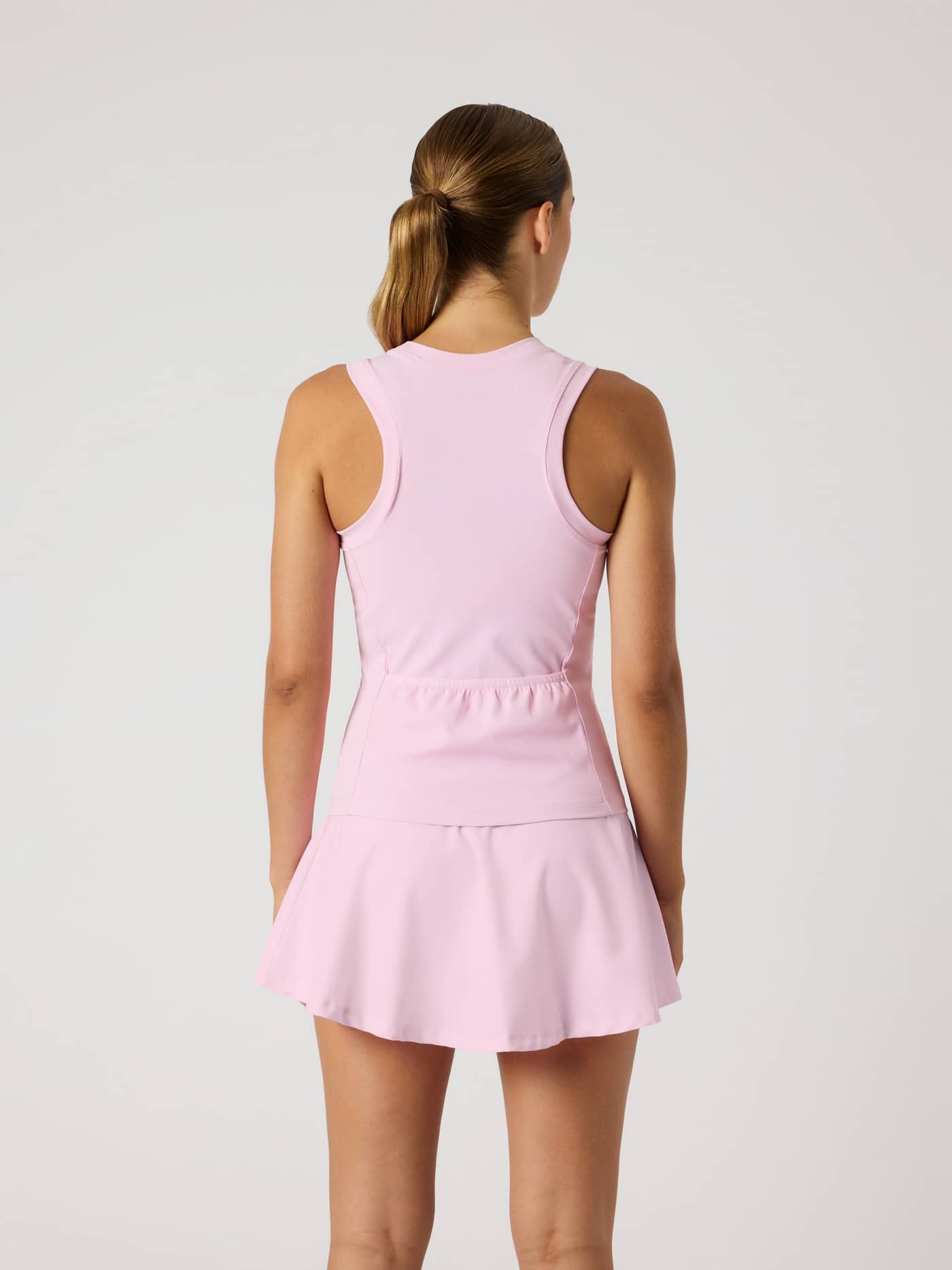 Back view of a model in the slim-fit Björn Borg Ace Pocket Ribbed Tank Top in Pink Lady (Pink) with a racerback for tennis. - Image 2
