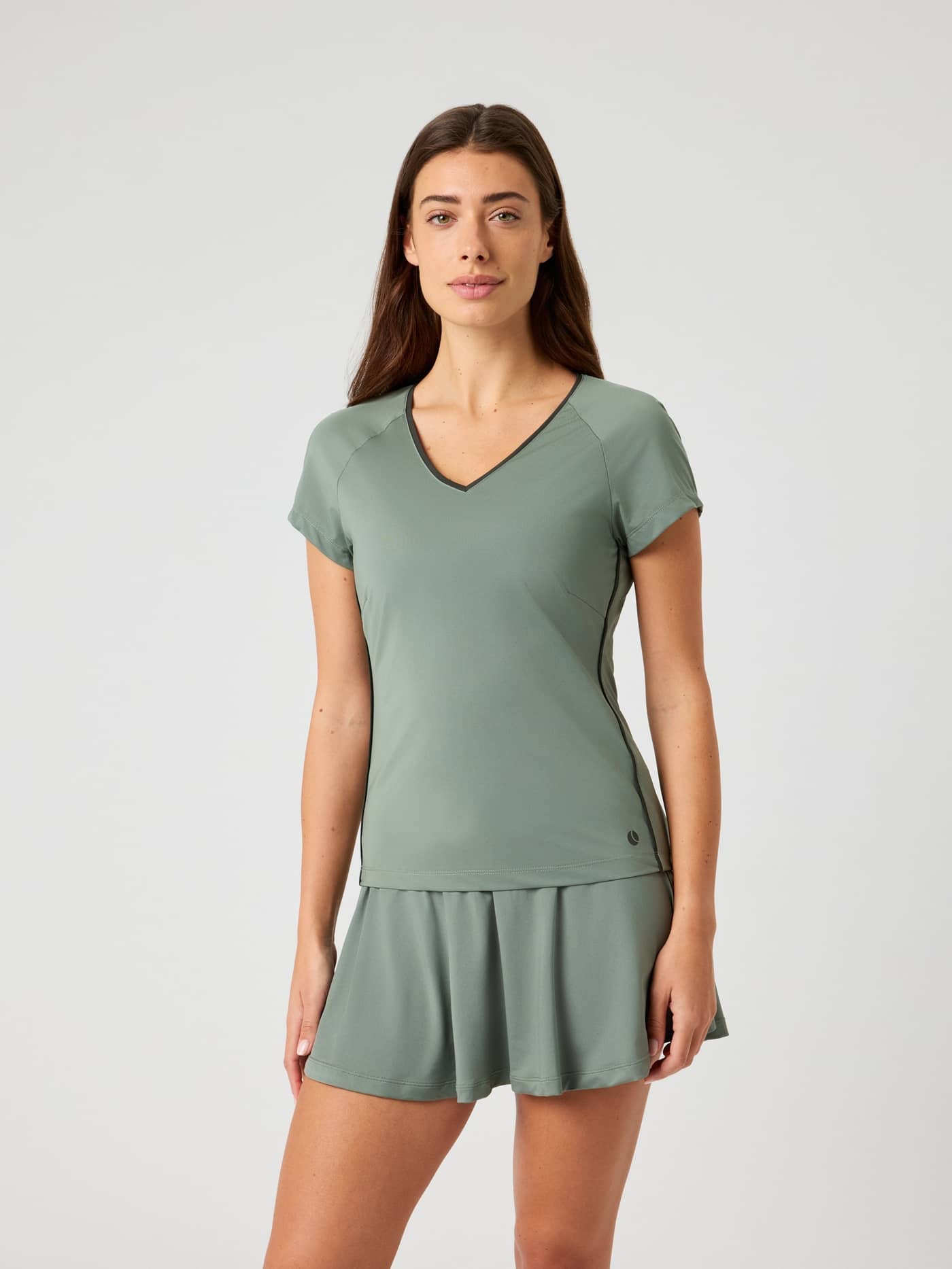 Björn Borg Ace V-Neck T-Shirt in Agave Green (Groen) met een bijpassende tennisrok voor dames in vooraanzicht. - Image 1