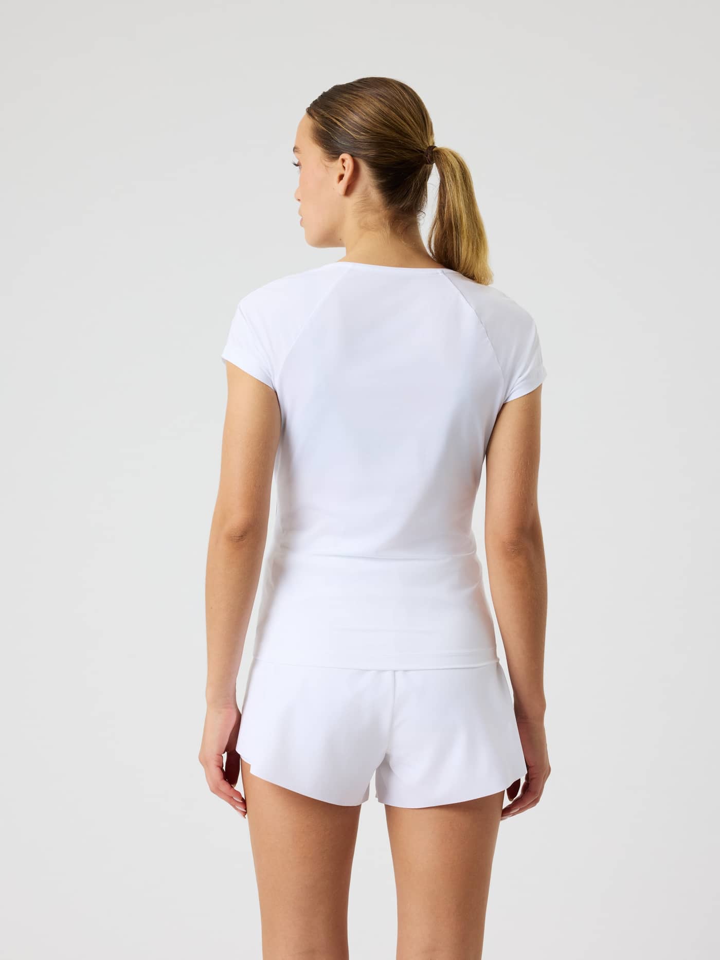 Back view of a model wearing the Björn Borg Ace V-Neck T-Shirt in Brilliant White (White) with a stylish slim tennis fit. - Image 2