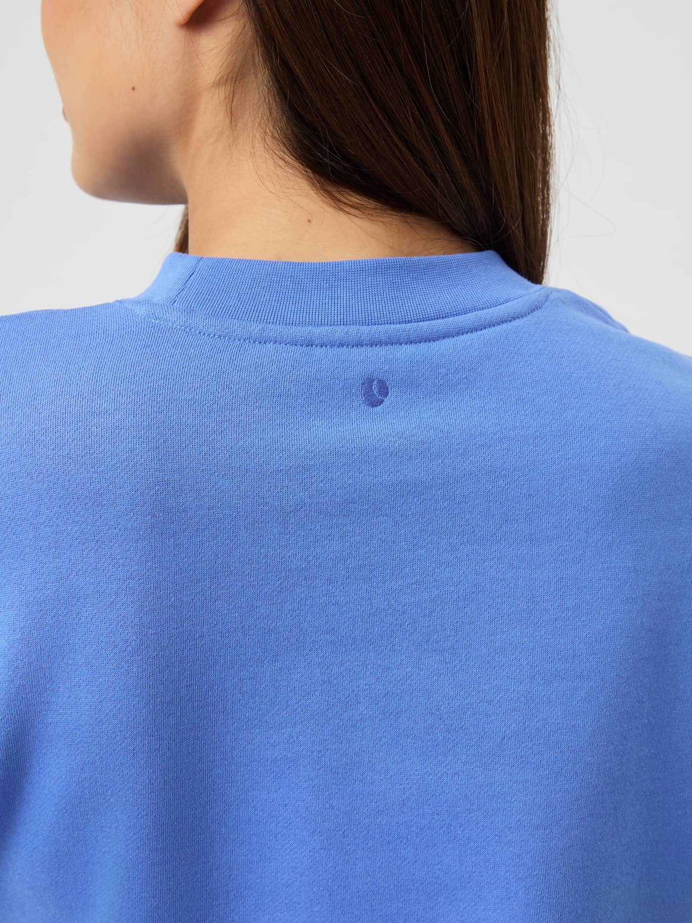 Gros plan de dos du Studio Oversized Cropped Sweatshirt Ultramarine (Bleu) avec logo tennis ton sur ton pour l'entraînement. - Image 4