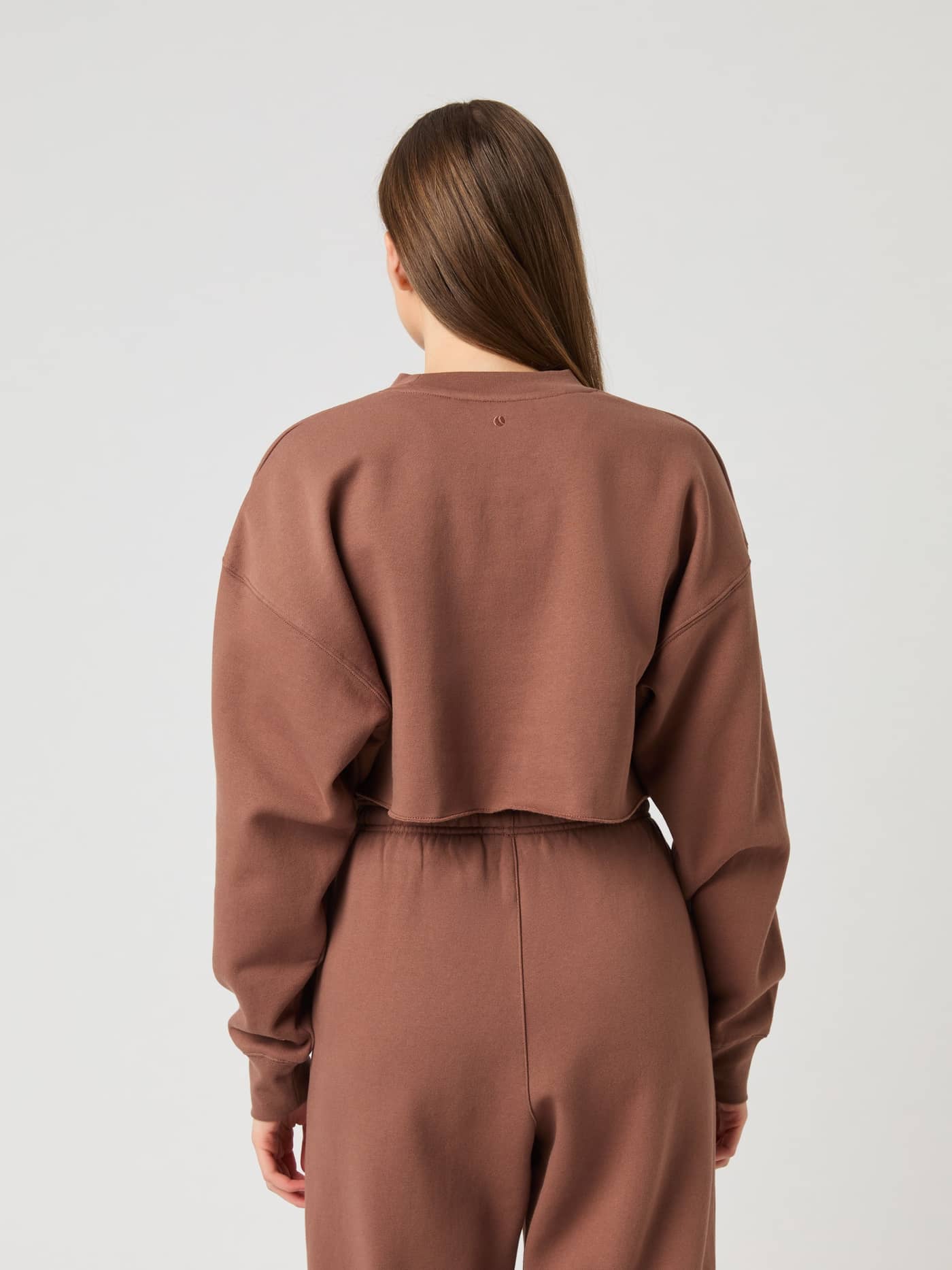 Back view of the Studio Oversized Cropped Sweatshirt in Acorn (Brown), featuring raw edges and a relaxed fit for training. - Image 2