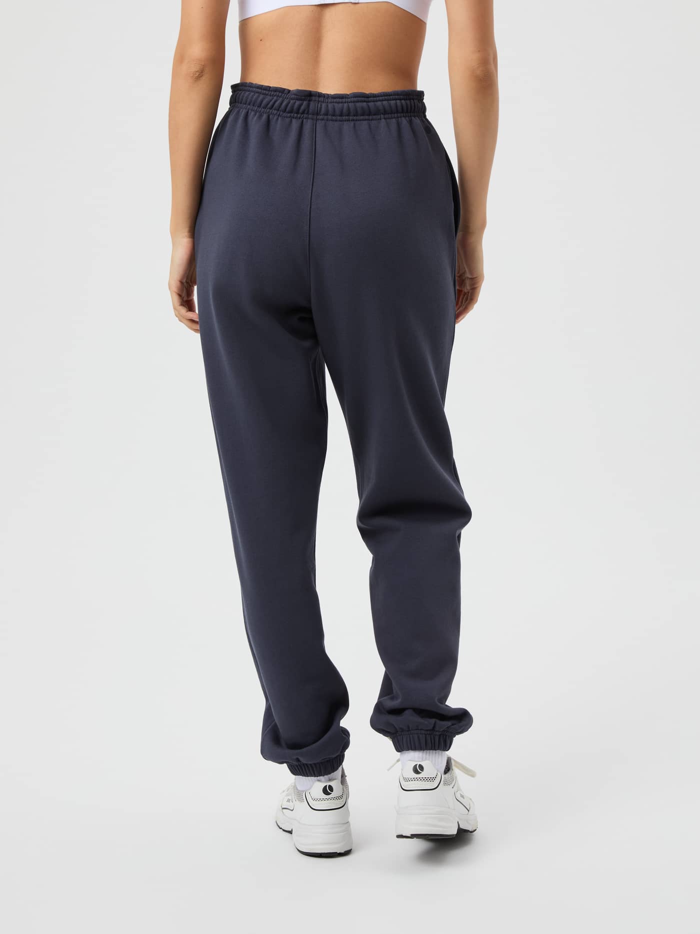 Back view of a woman wearing the Studio Oversized Sweatpants in Odyssey Gray (Grey) for studio training. - Image 3