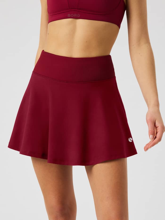 Front view of the Ace Skirt Pocket in Cabernet (Burgundy) featuring a high waistband and tennis ball logo.