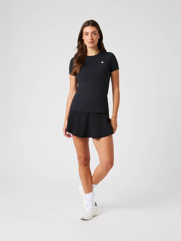 Front view of a model wearing the black Björn Borg Ace Skirt Pocket as part of a tennis outfit.