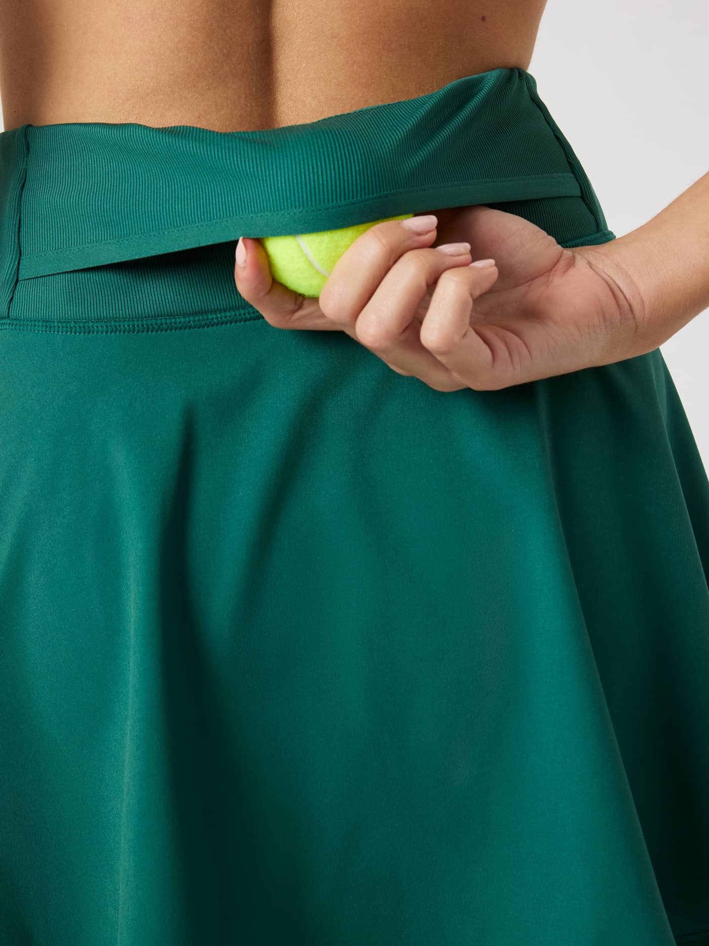 Close-up of the Björn Borg Ace Skirt Pocket in Posy Green (Green) showing the functional back tennis ball pocket. - Image 5