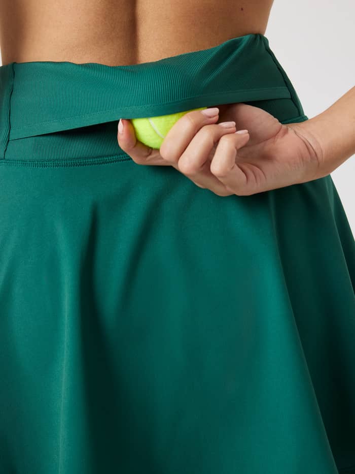 Close-up van de Ace Skirt Pocket in Posy Green (Groen) met de functionele tennisbalzak op de achterkant. - Image 5