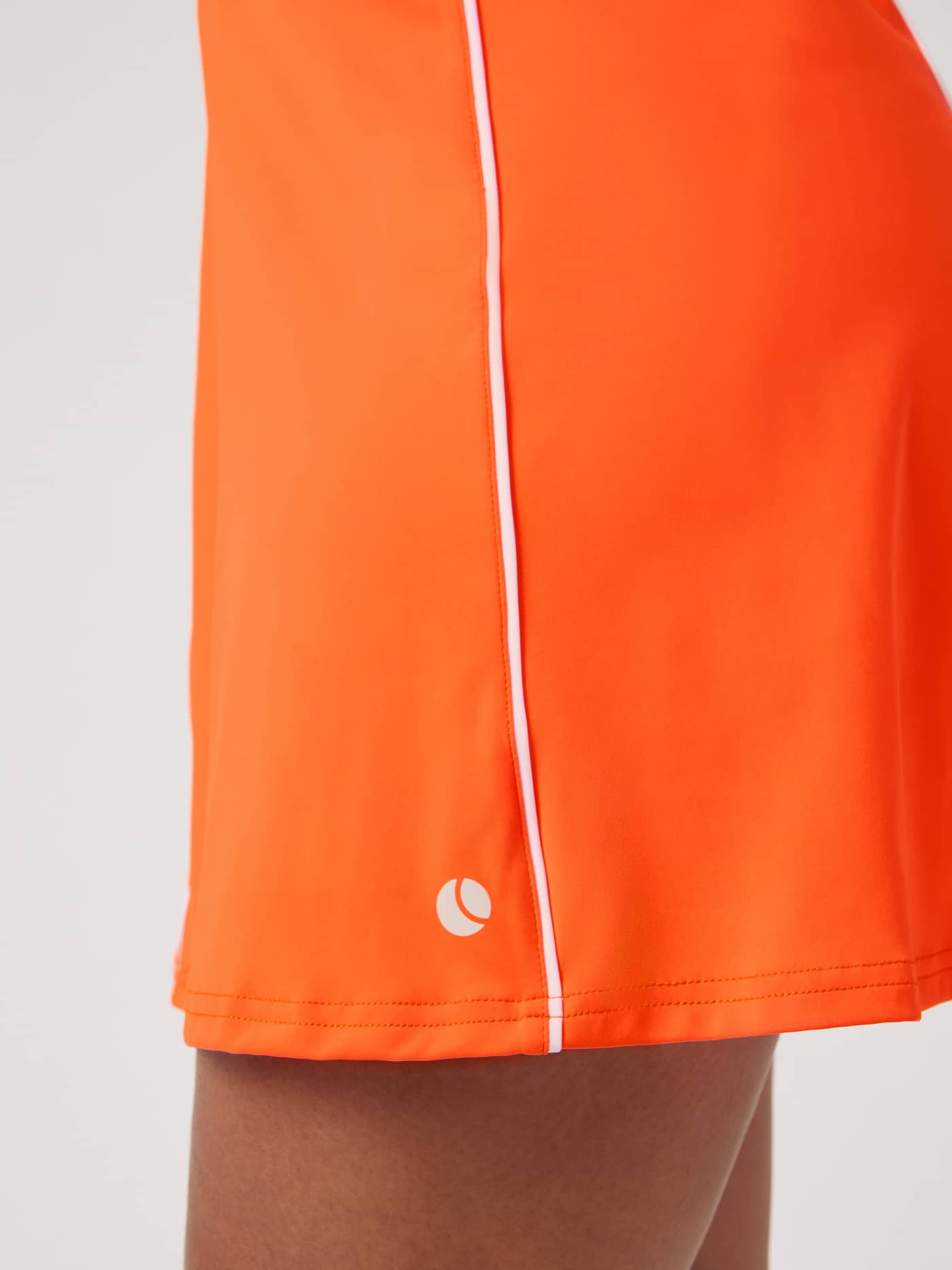 Detailansicht des Ace V Dress für Damen in Shocking Orange (Orange) mit weißem Tennisball-Logo für Tennis. - Image 5