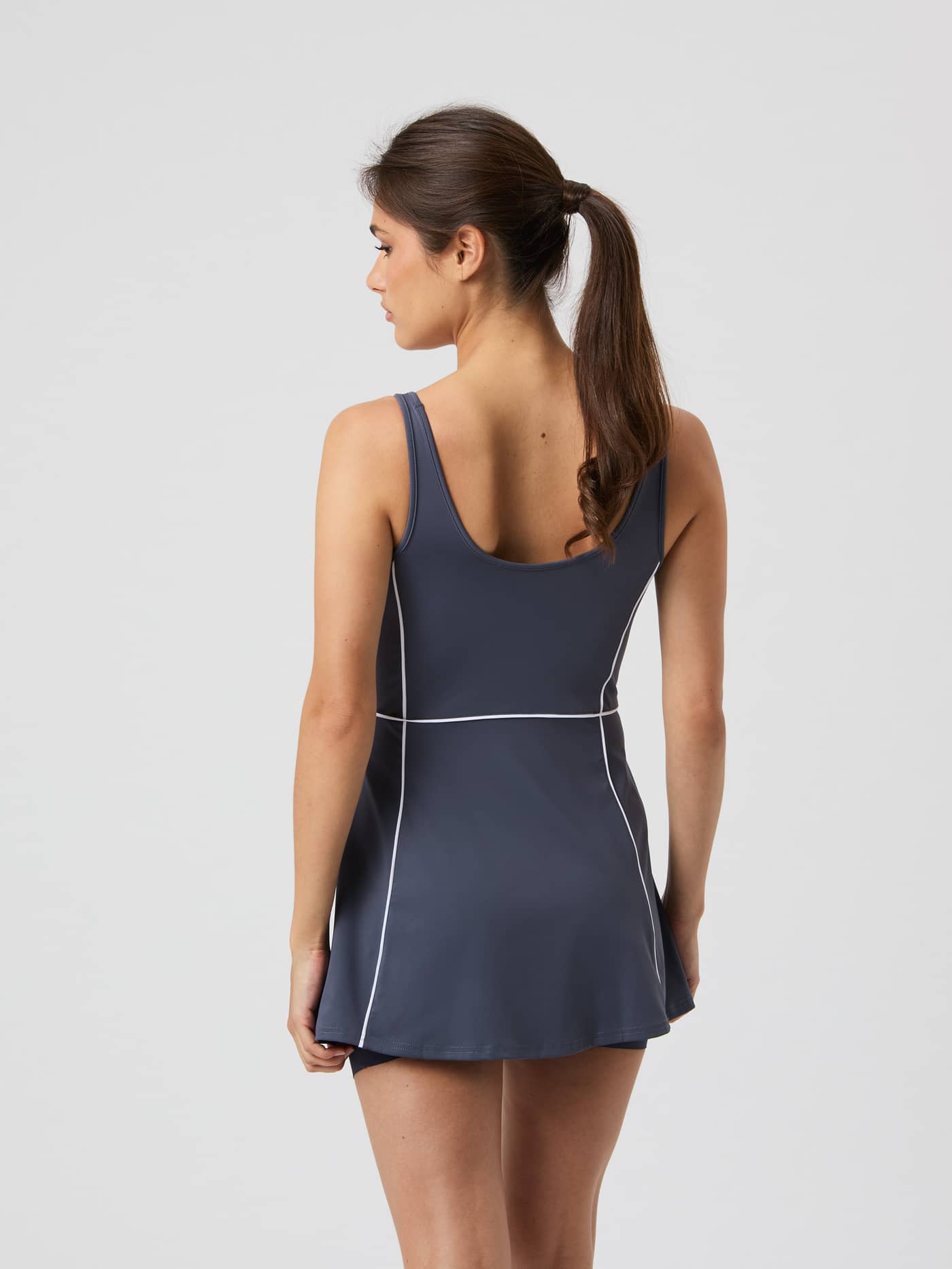 Back view of a model in the Odyssey Gray (Grey) Björn Borg Ace V Dress, a high-stretch tennis dress with a stylish low back. - Image 2