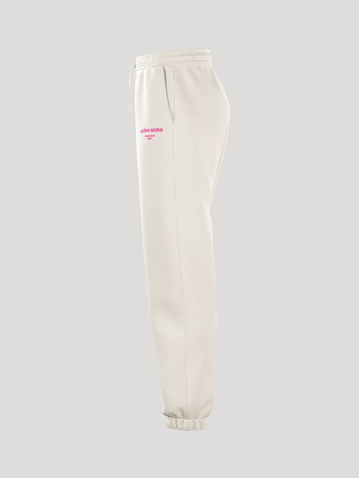 Borg Essential 1 Sweatpants i Tofu (Hvid) til damer, set fra siden med en løs pasform og pink logoprint. - Image 4