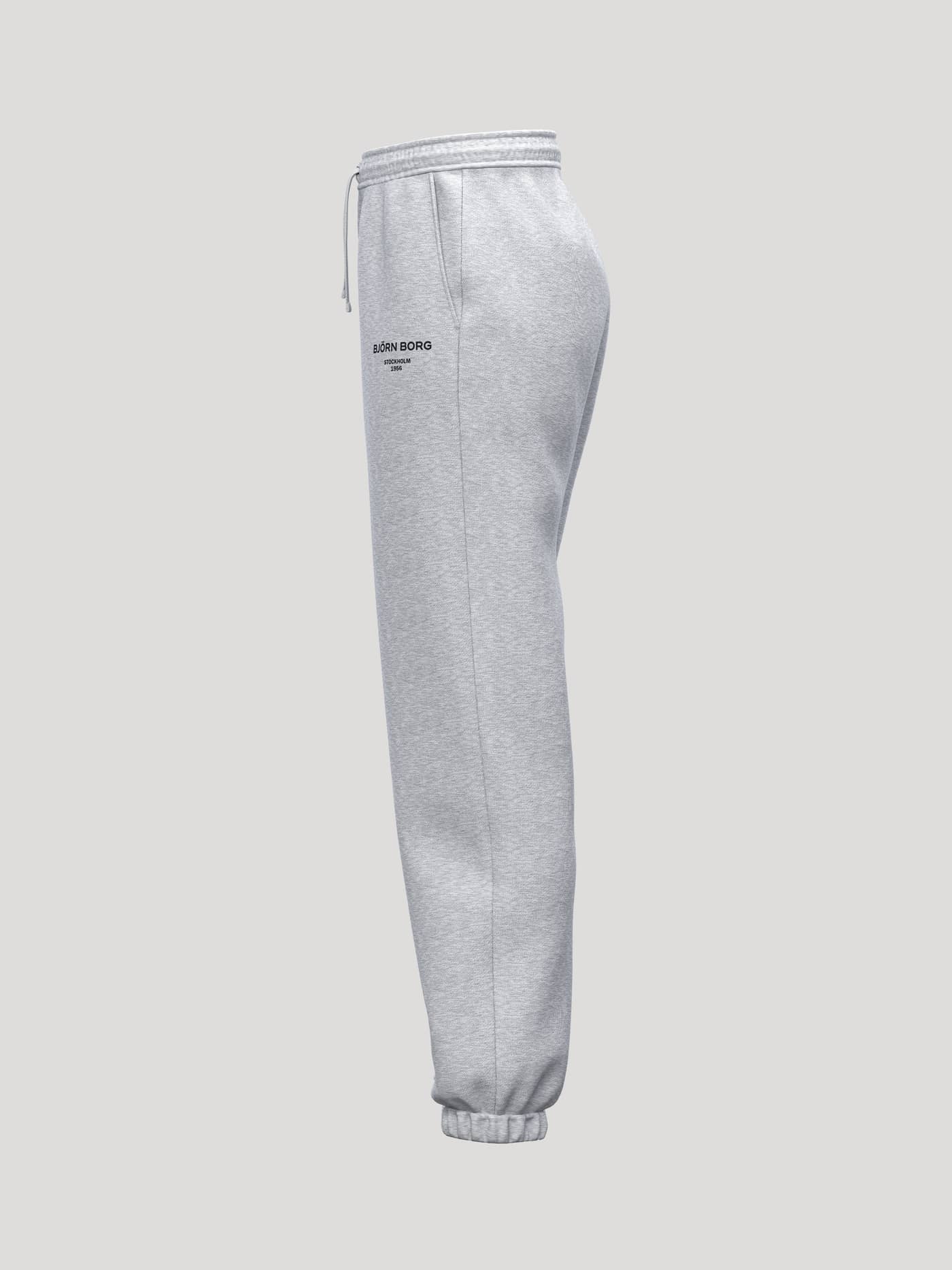 Side view of the Borg Essential 1 Sweatpants in Light Grey Melange (Grey), featuring ribbed cuffs and a black logo. - Image 3