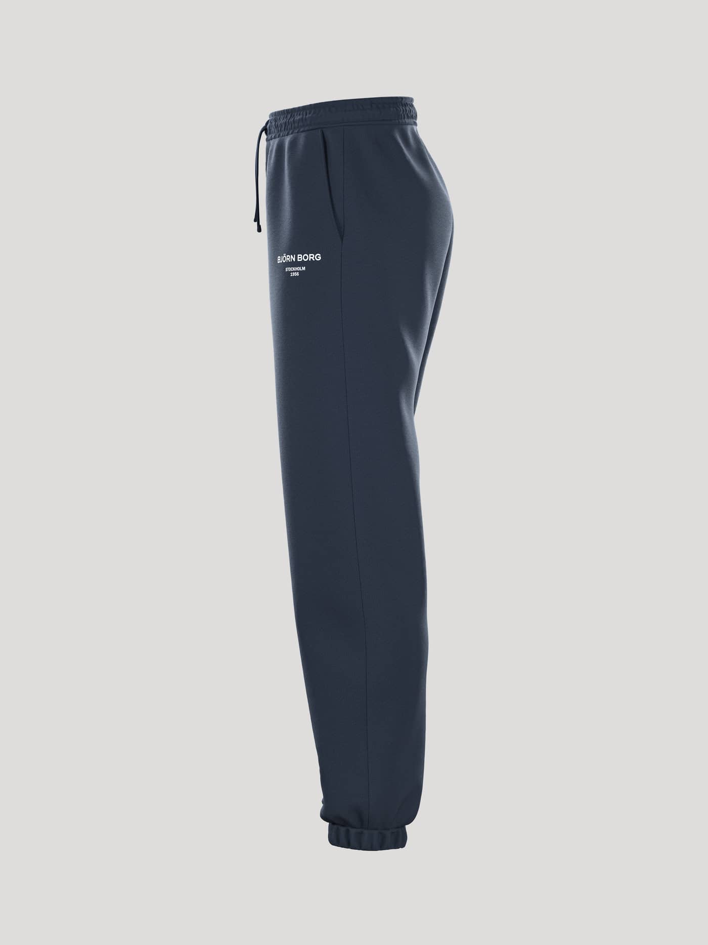 Zijaanzicht van de Borg Essential 1 Sweatpants in Outerspace (Marineblauw) met een losse pasvorm en een wit logo. - Image 4