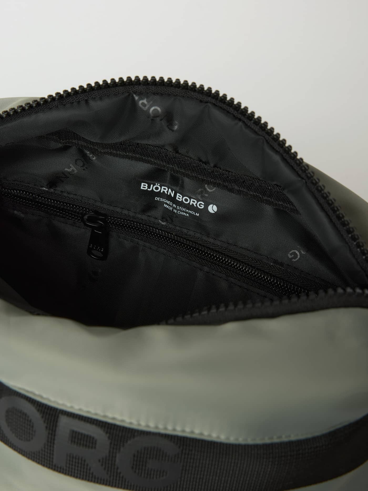 Innenansicht der Borg Classic Crossover Bag 2,5 L in Agave Green (Grün) mit weißem Logo und schwarzer Reißverschlusstasche. - Image 3