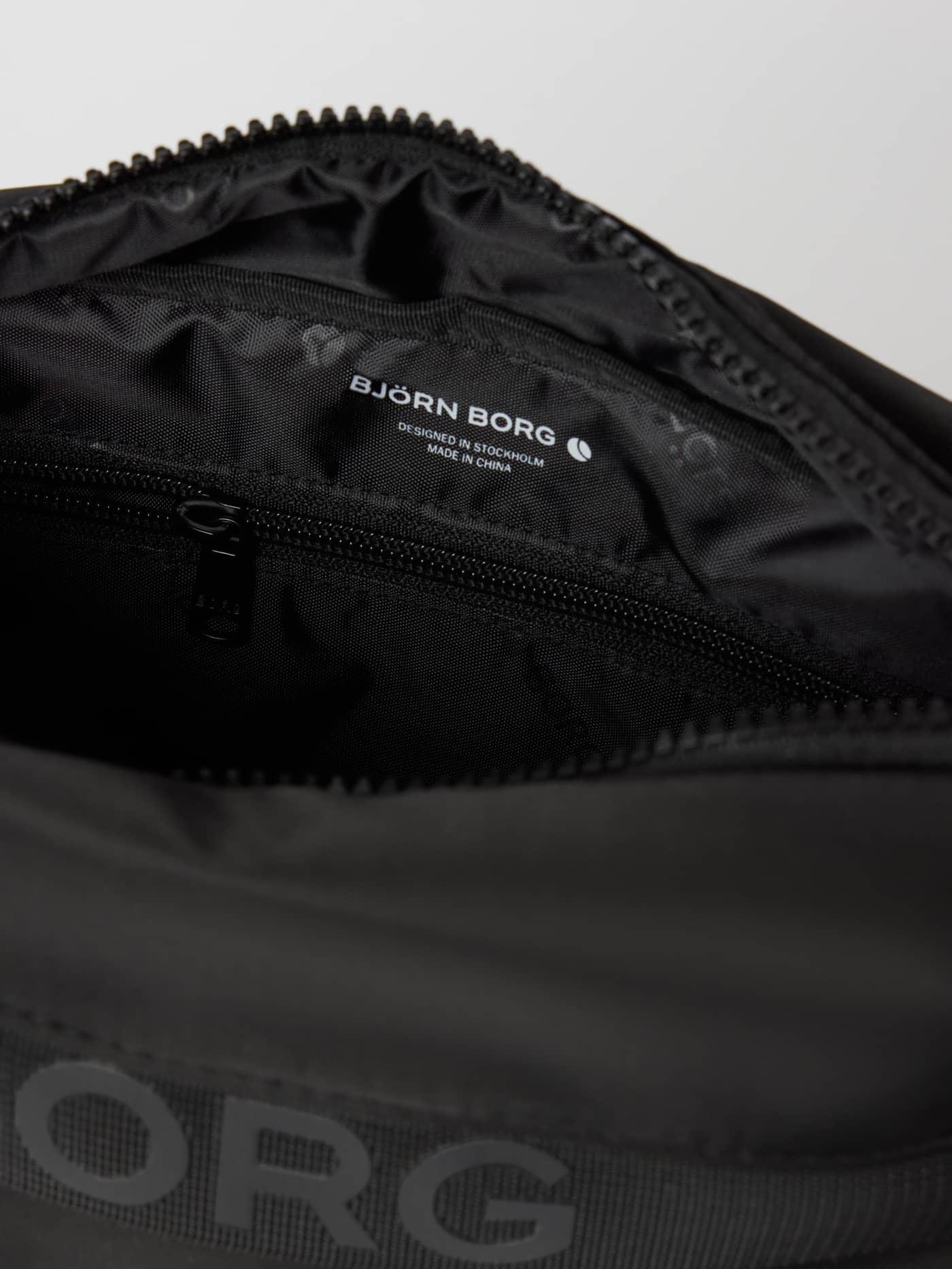 Innenansicht der Borg Classic Crossover Bag 2,5 L in Black Beauty (Schwarz) mit Reißverschlussfach und weißem Logo. - Image 3