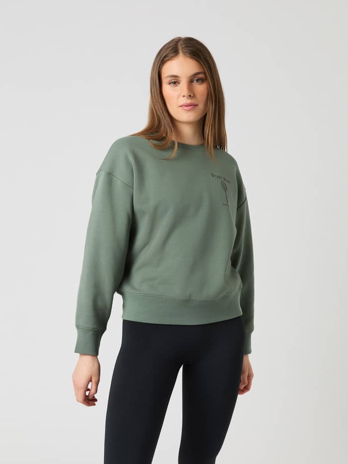 Vorderansicht eines Models im oversized Borg Boyfriend Sweatshirt in Agave Green (Grün) mit Tennis-Grafik und modernem Fit. - Image 3