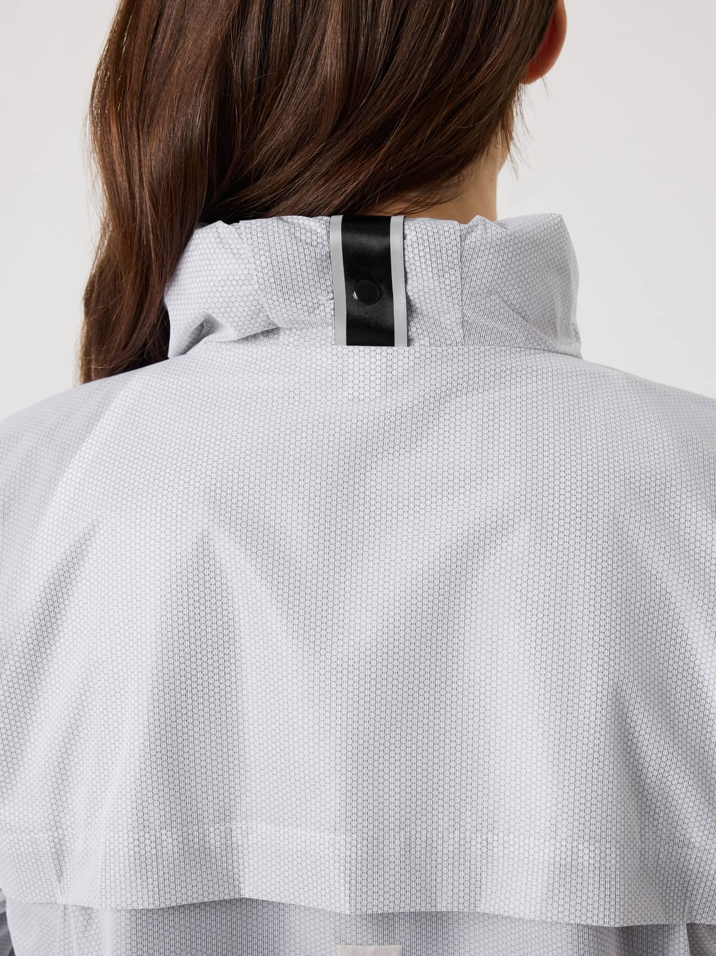 Nahaufnahme der Rückseite der Borg Running Jacket in Brilliant White (Weiß) mit faltbarer Kapuze für Damen zum Running. - Image 6