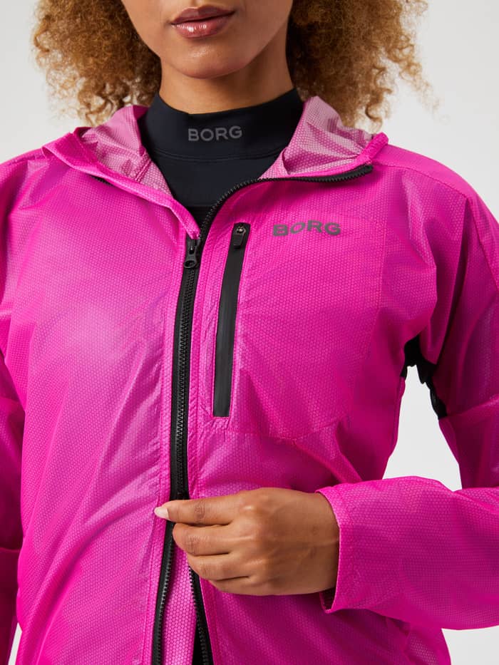 Close-up of the Borg Running Jacket in Pink Glo (Pink) for women, with a black logo and textured performance fabric. - Image 4
