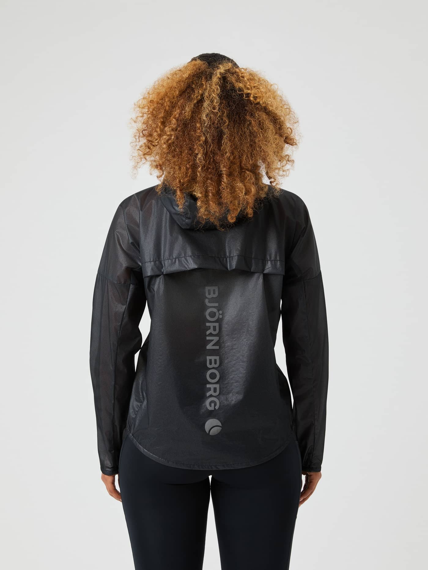 Rückansicht einer Frau in der Borg Running Jacket mit regulärem Fit in Black Beauty (Schwarz) und grauem vertikalem Logo. - Image 2