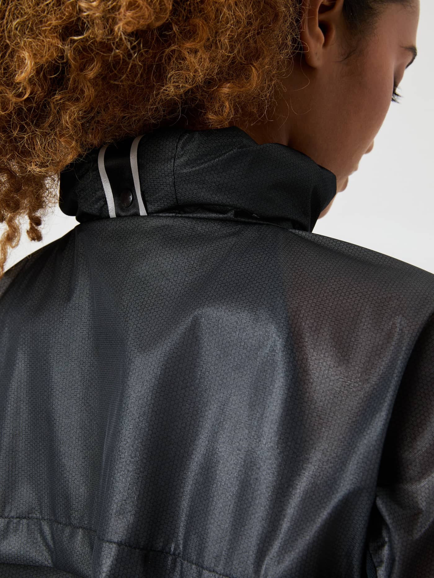 Nahaufnahme der Borg Running Jacket in Black Beauty (Schwarz) mit reflektierendem Kragen und Muster für Running. - Image 6
