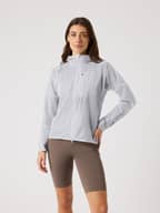 Front view of a woman in the Borg Running Jacket in Brilliant White (White), a lightweight performance layer for running.