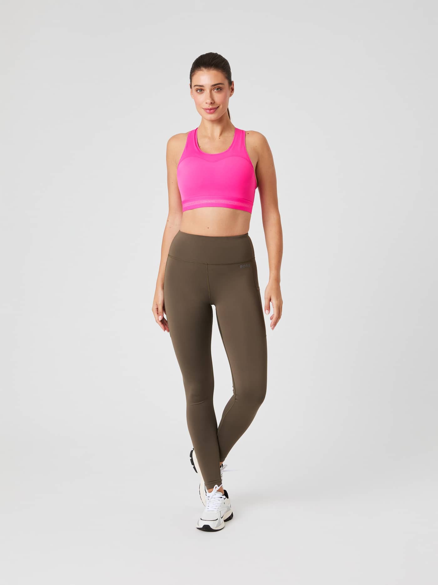 Full-body front view of a woman wearing the pink Björn Borg High Support Bra, providing a secure fit for intense training. - Image 4