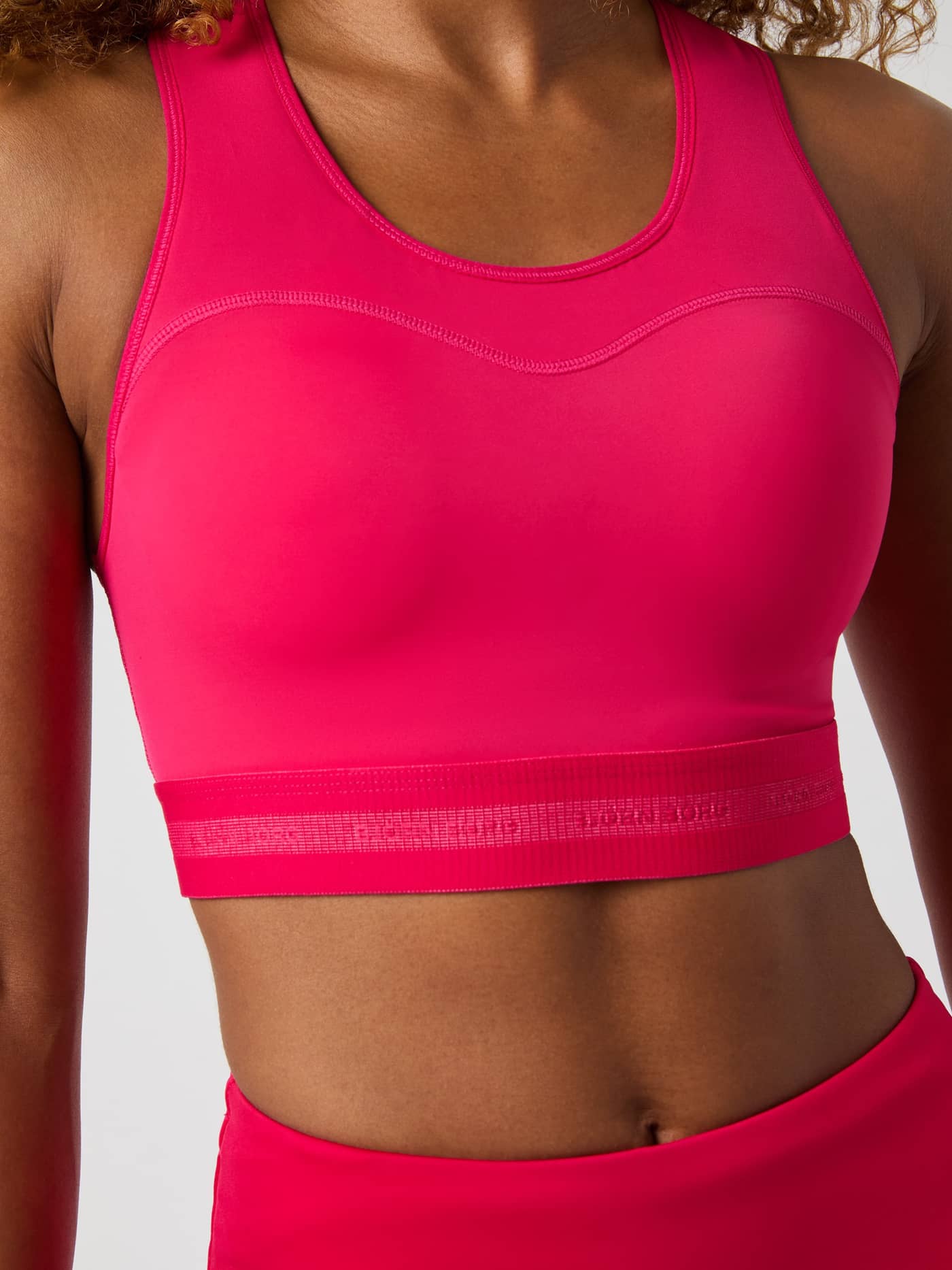 Front view of a model wearing the pink Björn Borg High Support Bra, featuring a secure fit for running and training. - Image 4