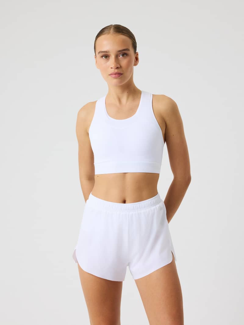 Front view of a model in the white Borg Performance High Support Bra, designed for a perfect fit during training and running.