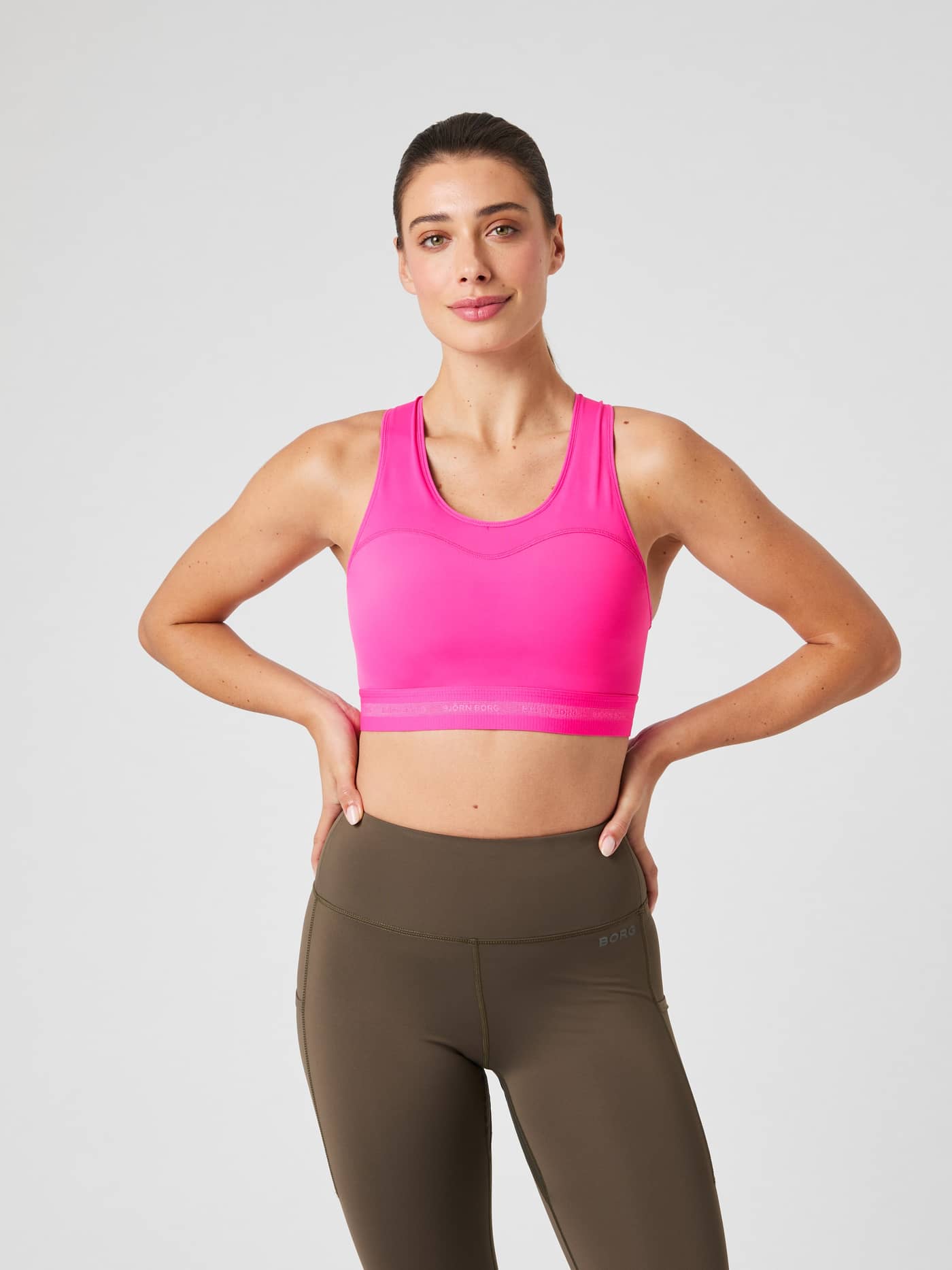 Front view of a model wearing the pink Borg High Support Bra for running and high-intensity training. - Image 2