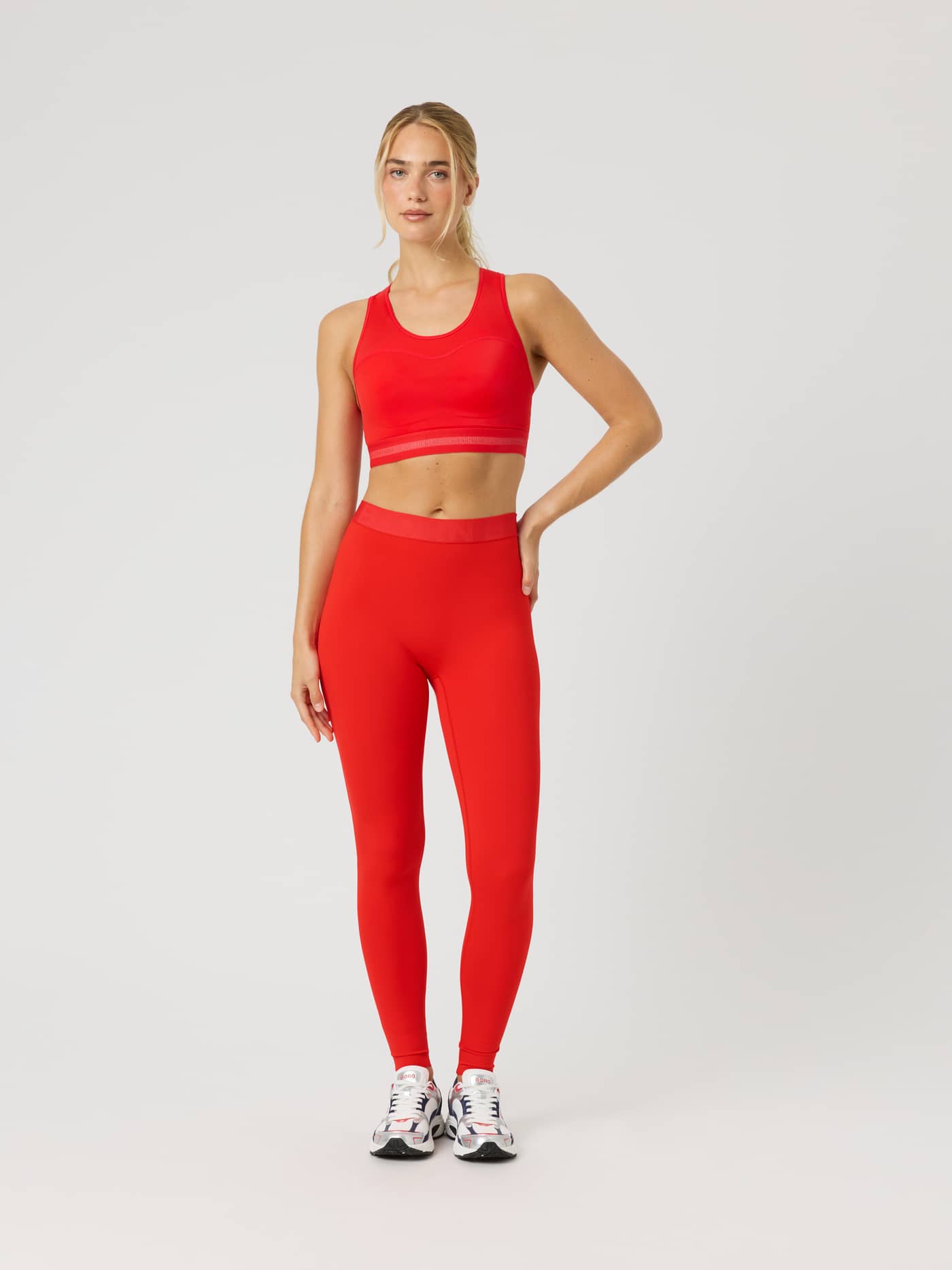 Full-body front view of a model wearing the Borg Performance High Support Bra in Red for running and training. - Image 3