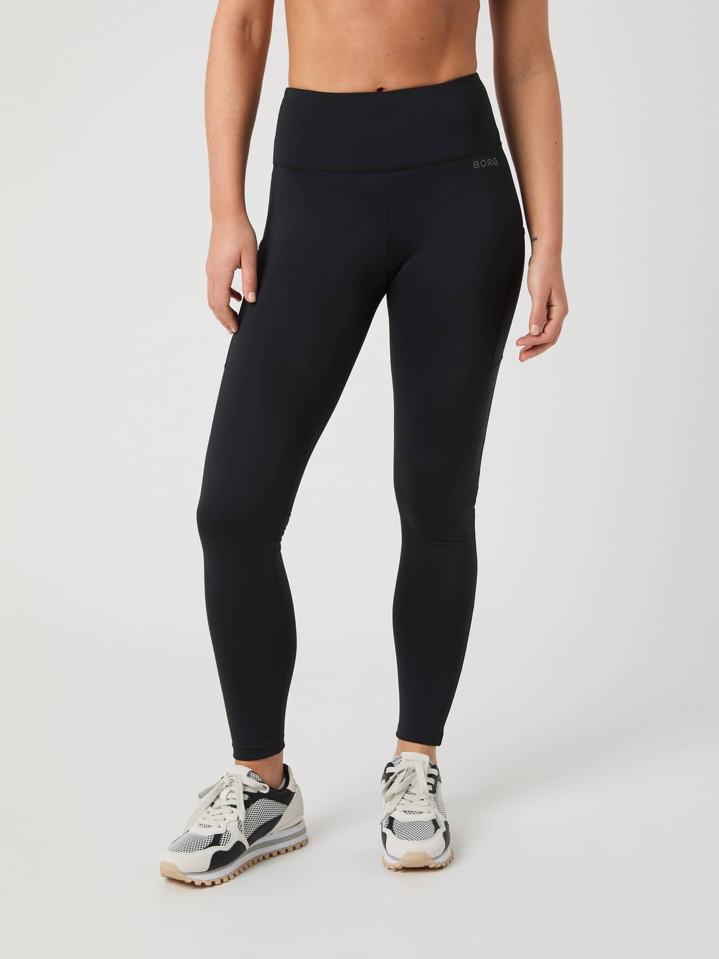Front view of a woman wearing the slim-fit Borg Running Tights in Black Beauty (Black) for performance running. - Image 3