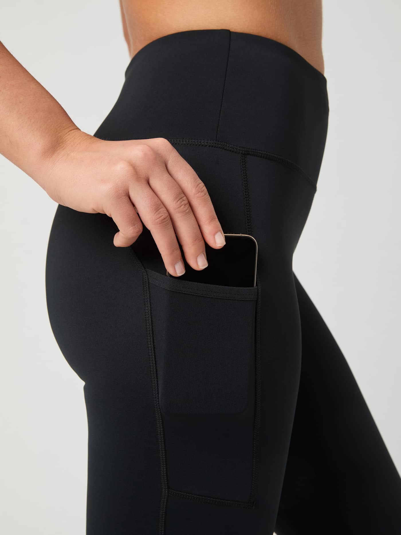 Close-up of the upper leg phone pocket on the Borg Running Tights in Black Beauty (Black), showing the slim fit. - Image 5
