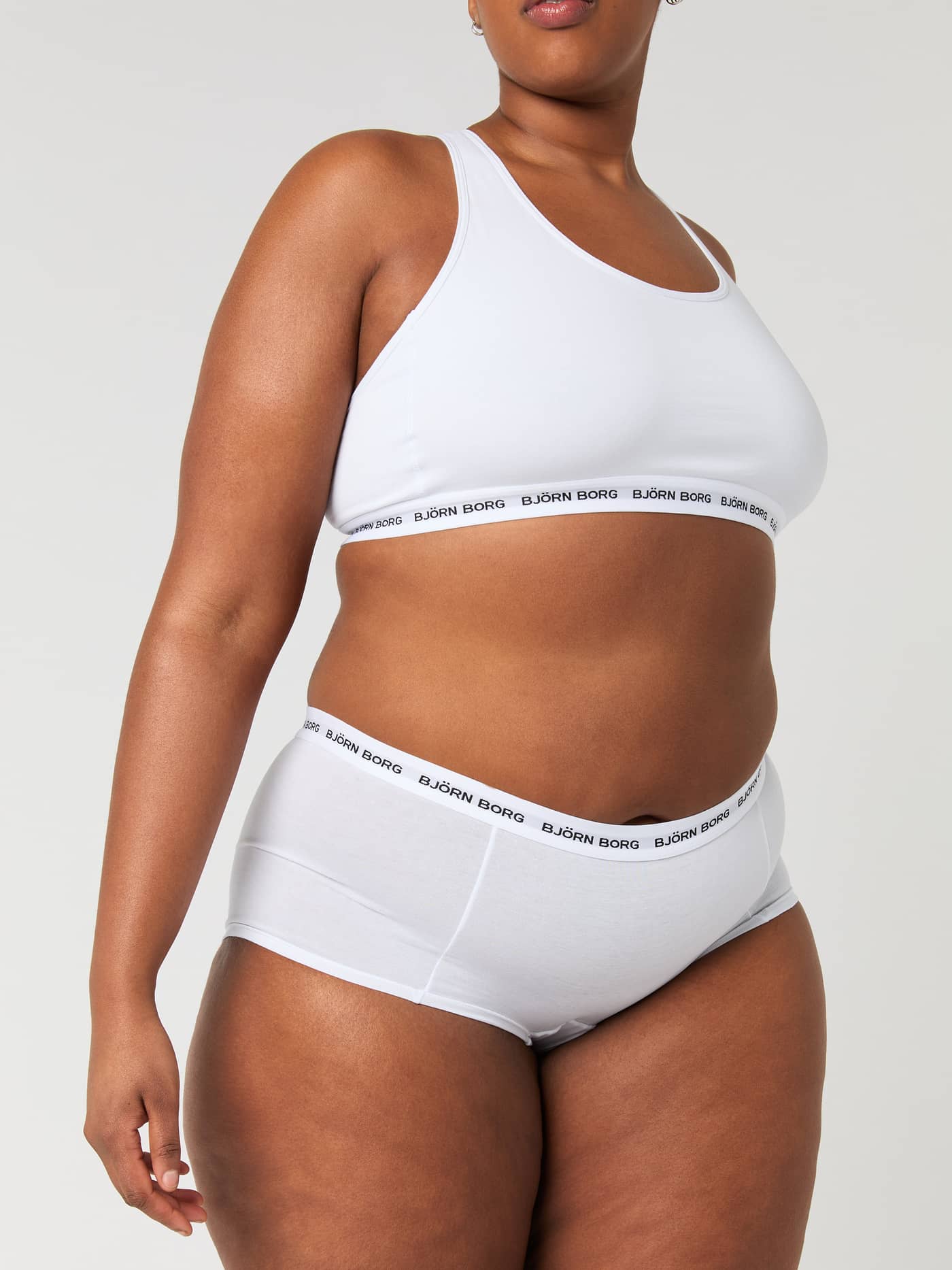 Front-side view of a model wearing the white Logo Boxer Shorts 3-pack, featuring a mid-rise waist and black logo waistband. - Image 6
